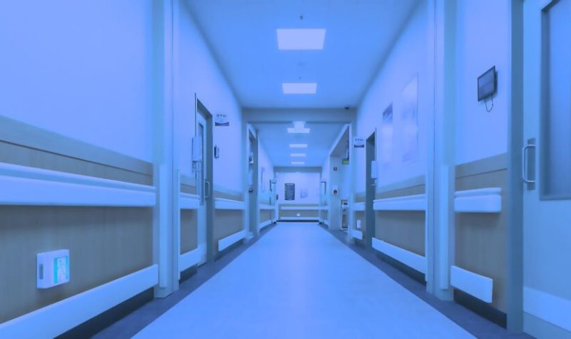 Un corridor d'hôpital vide saturé d'un filtre bleuté.