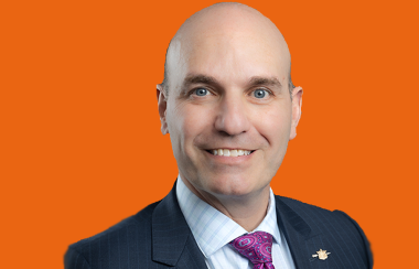 A headshot of Nathan Cullen on an orange background