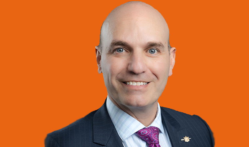 A headshot of Nathan Cullen on an orange background