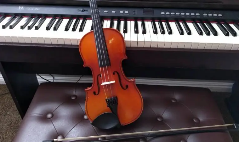 un violon posé sur un piano