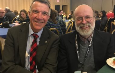 A photo of David Gillespie with Vermont Governor Phil Scott, with Gillespie on the right in a jacket and glasses, and Scott on the left in a suit and red tie.