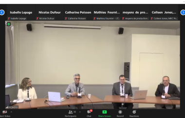 A screenshot of a zoom meeting showing four people sitting at a table.