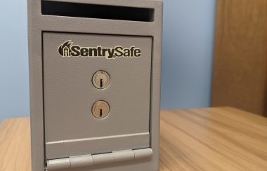 A small grey safe sits on a desk.