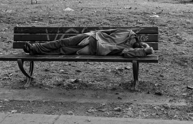 Personne itinéante dormant sur un banc de parc