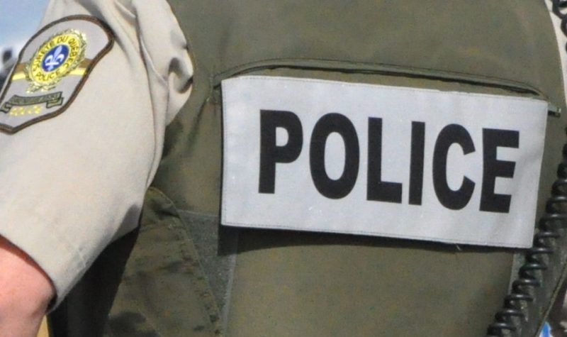 A photo of the word police (SQ) on the back of a police vest.