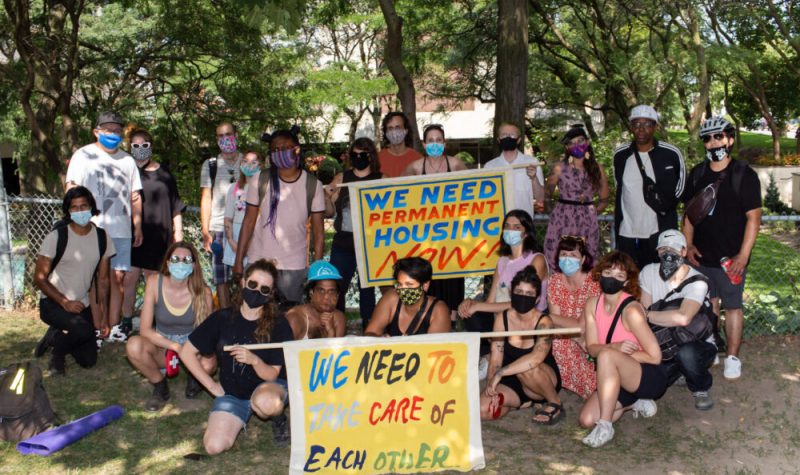 A photo of the Encampment Support Network (ESN) community holding signs.
