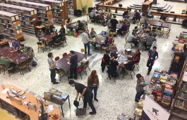 People gaming at Estrie Joue board gaming event. The photo is taken from a second storey looking down onto the first story.