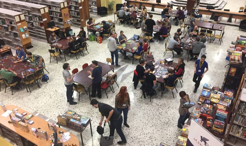People gaming at Estrie Joue board gaming event. The photo is taken from a second storey looking down onto the first story.