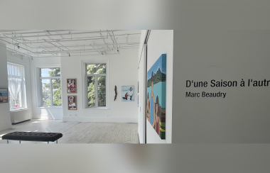 L'exposition d'art de Marc Beaudry avec le titre à droite du mur qui dit « D'une saison à l'autre » et quelques peintures accrochées sur le mur blanc près d'une grande fenêtre.