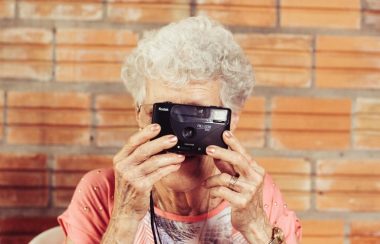 Une dame âgée tenant un appareil photo