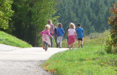 Un groupe d'enfants marchent ensemble sur un trottoir.