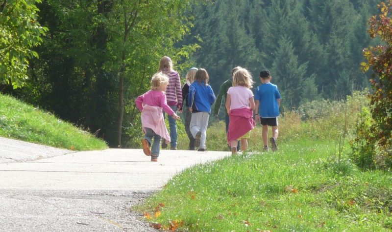 Un groupe d'enfants marchent ensemble sur un trottoir.