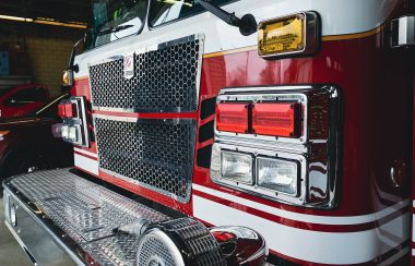 The front of red firetruck pictured parked in parking garage