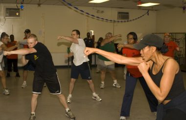A group of people throw fists in a fitness class.
