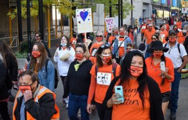 People of all ages and nationalities wearing orange shirts for an annual orange shirt day in Calgary.