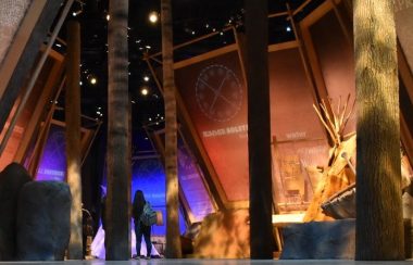 Indigenous lady looking at art display at Fort Edmonton Park exhibit