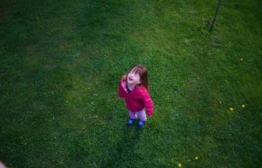 A young child has a tantrum in a backyard