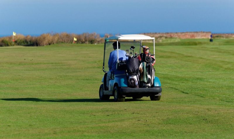 Un chariot de golf sur un terrain d'herbe.