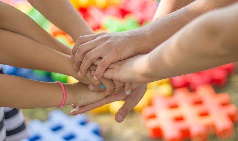Des mains d'enfants devant des signes dièses de différentes couleurs