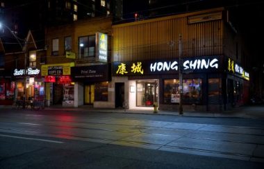 The outside of Hong Shing restauran across the street at night