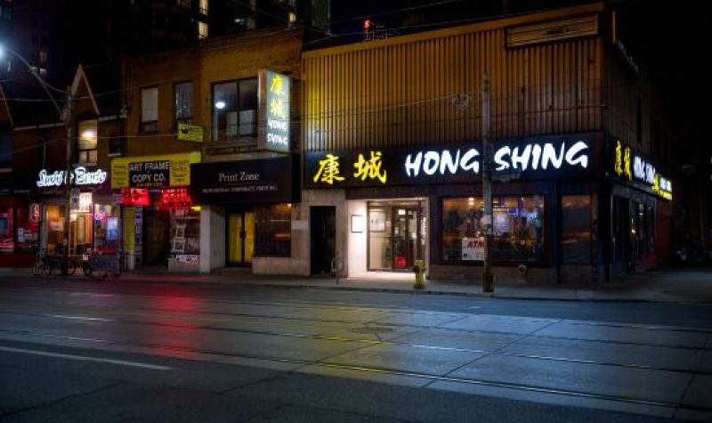 The outside of Hong Shing restauran across the street at night
