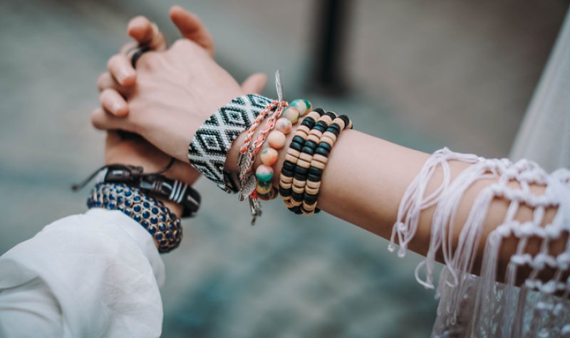 Deux femmes se tiennent la main portant au poignet des bracelet de perles autochtones.