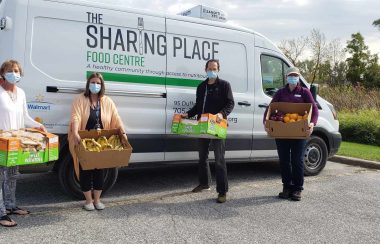 Des bénévoles devant le camion de la banque alimentaire The Sharing Place Food Centre