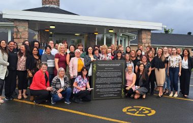 Les employés de la Résidence MGR Melanson à Saint-Quentin, toutes des femmes, devant leur lieu de travail affichant le prix de reconnaissance offert par leurs employeurs