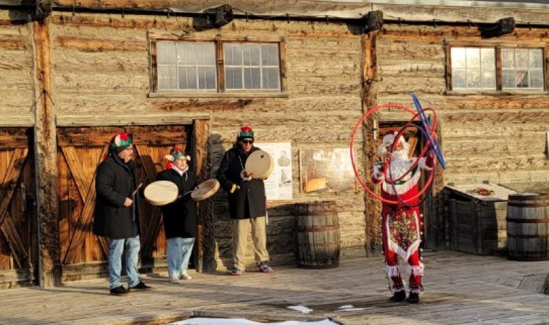 A performance of Blackfoot Santa, otherwise known as Napi. The performance featuring songs and dance. Weather is sunny.