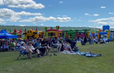 Des châteaux gonflables et des gens assis sur des chaises de camping.