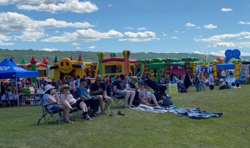 Des châteaux gonflables et des gens assis sur des chaises de camping.