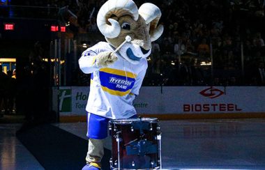 A Ram mascot costume drums while standing on an ice hockey rink