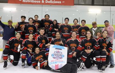 Saddle Lake Cree Nation's U18 hockey team all posing around their freshly won championship banner. Photo was taken on the ice, just after the game.