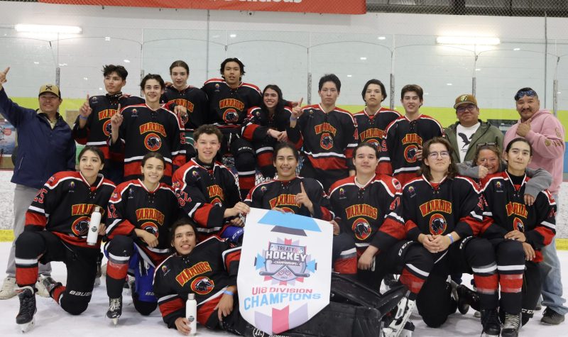 Saddle Lake Cree Nation's U18 hockey team all posing around their freshly won championship banner. Photo was taken on the ice, just after the game.