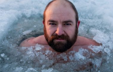 Un homme barbu dans de l'eau glacée