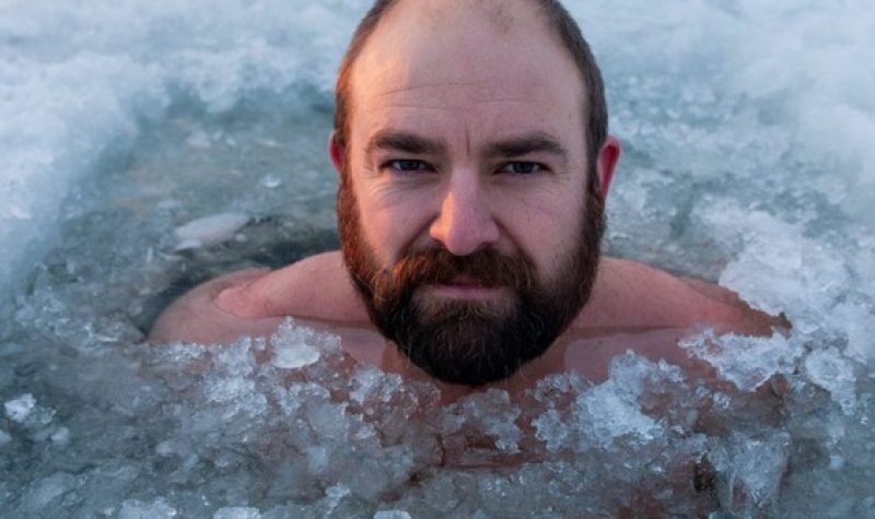 Un homme barbu dans de l'eau glacée