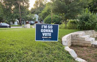 A stock photo of a voting sign on a lawn.