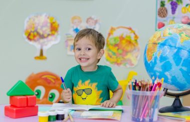 Un enfant souriant à son bureau d'école