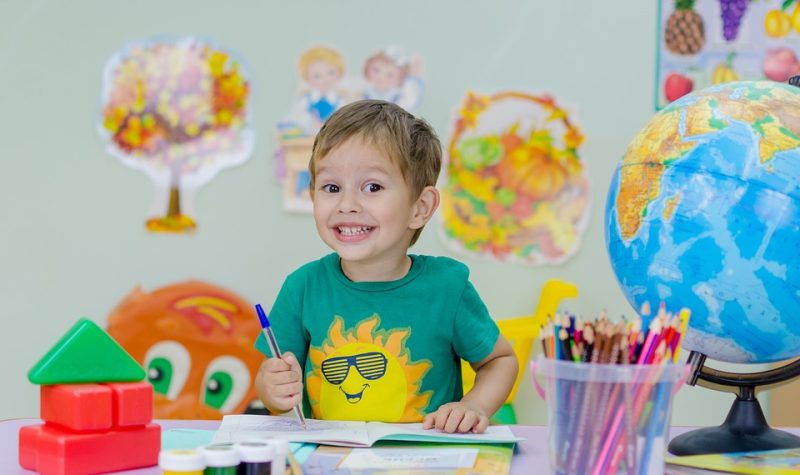 Un enfant souriant à son bureau d'école
