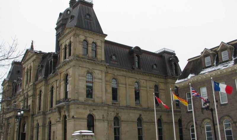 On vois le parlement du Nouveau-Brunswick dont les abords sont enneigés.