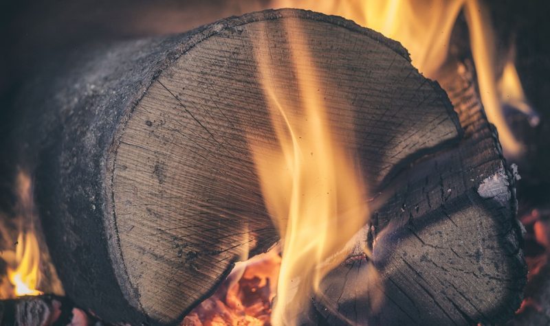Une grosse buche de bois entourée de flammes