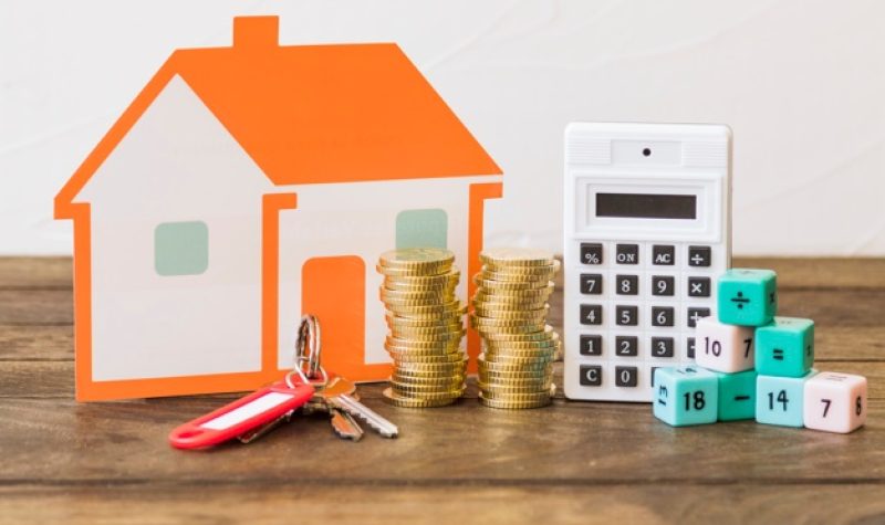 Image d'une maison, de l'argent et une calculatrice pour représenter la crise du logement.