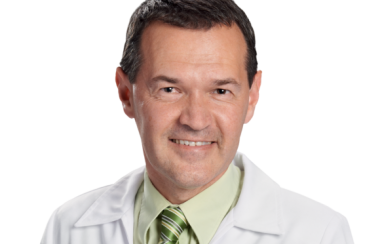 A headshot of pharmacist Marc Aufranc, wearing a green shirt and tie over a white jacket.