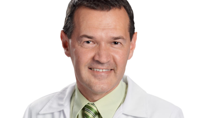 A headshot of pharmacist Marc Aufranc, wearing a green shirt and tie over a white jacket.