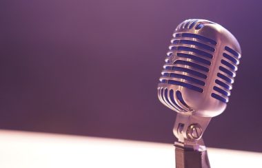 Close-up of a microphone lit by a purplish light.