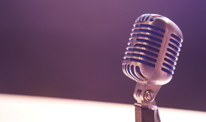Close-up of a microphone lit by a purplish light.