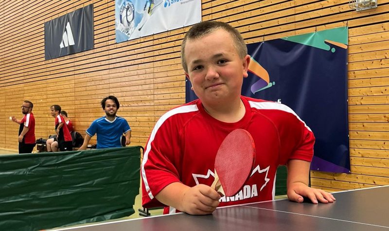 un jeune garçon avec une palette de ping-pong