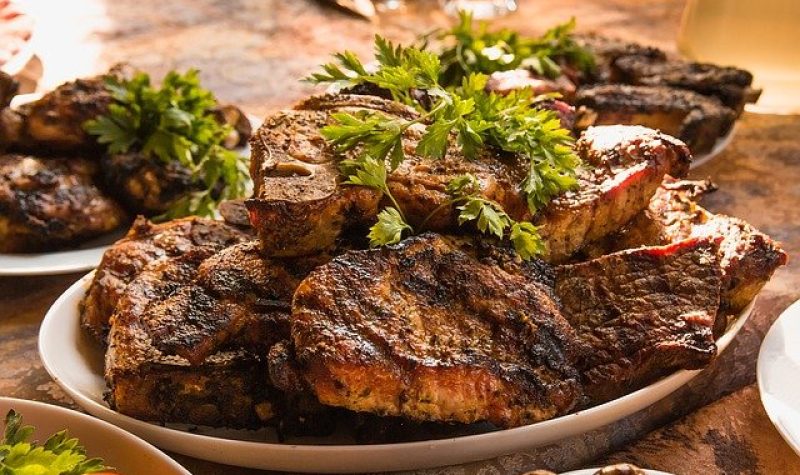 Assiette de steak de boeuf avec des feuilles de persil sur le dessus.