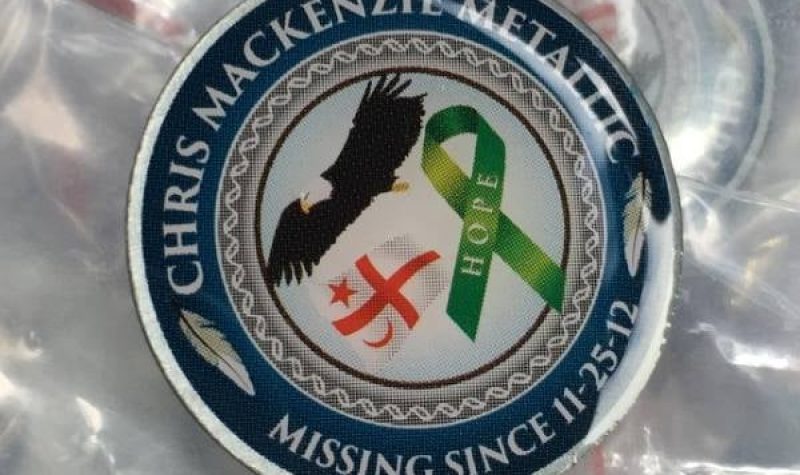 A ceramic pin with text: Chris Mackenzie Metallic, Missing since Nov 25, 2012 and images of a green ribbon, the Mikmaq flag and an eagle.