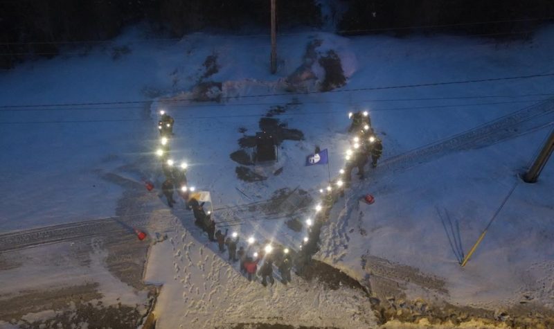 Photo prise de haut montrant des gens placés en forme de V et tenant des lumières